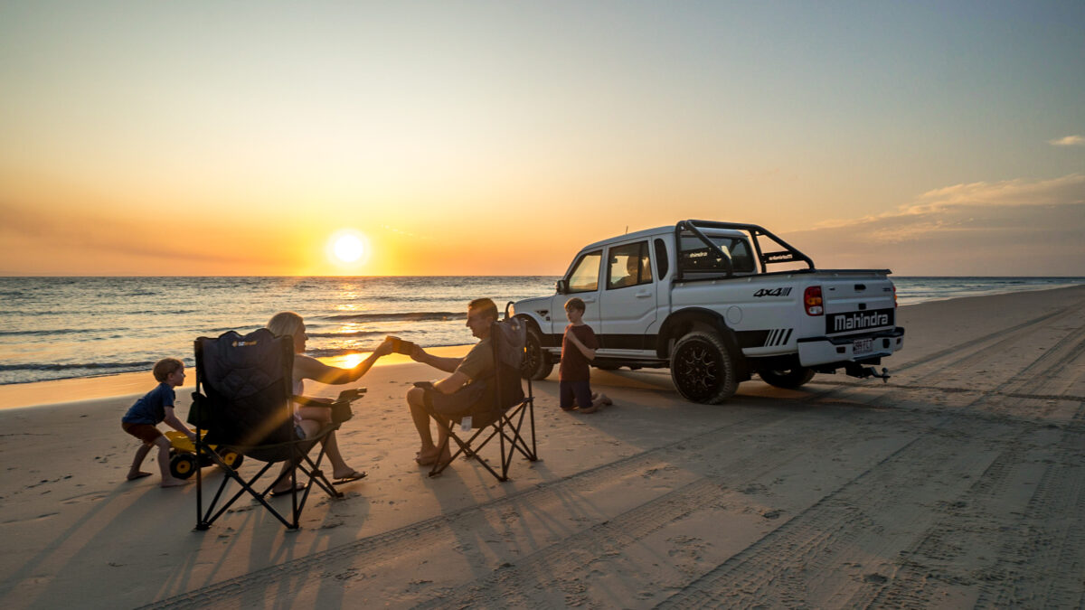 Mahindra pick-up adventure: Family of four cherishing a beach sunset together.