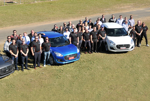 aerial shot of Suzuki QLD staff standing next to Suzuki Swifts